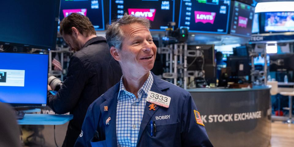 A smiling trader on the floor of the New York Stock Exchange.