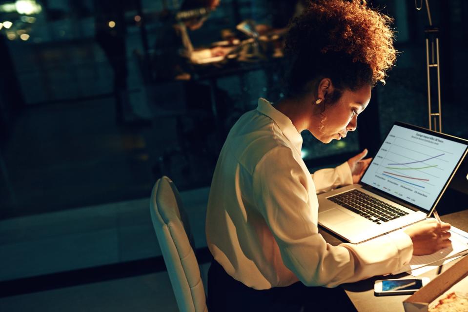 A person works on a laptop in an office.