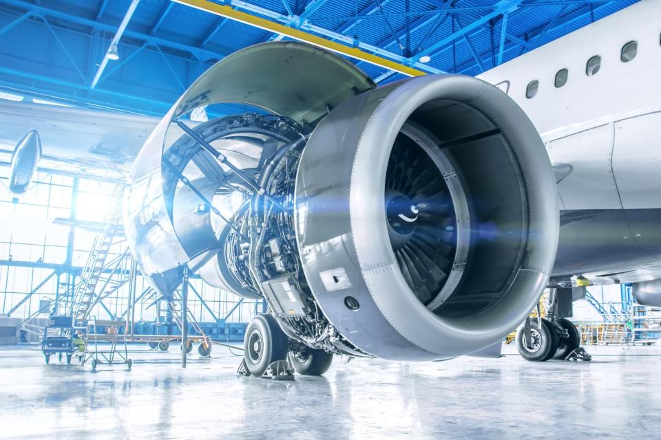 Airliner with one of its engines being serviced