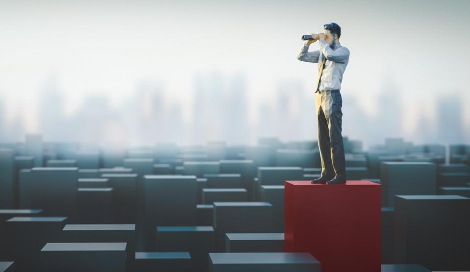 An illustration of a person looking through binoculars while standing on a red box amid a field of other boxes.