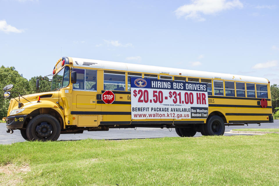 Monroe, Georgia, school bus parked by highway, help wanted, hiring bus drivers banner sign. (Photo by: Jeffrey Greenberg/Universal Images Group via Getty Images)