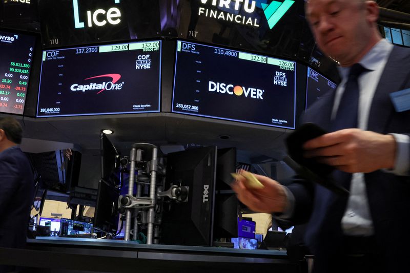 © Reuters. FILE PHOTO: Screens display the logos and trading information for Capital One Financial and  Discover Financial as traders work on the floor at the New York Stock Exchange (NYSE) in New York City, U.S., February 20, 2024.  REUTERS/Brendan McDermid/File Photo